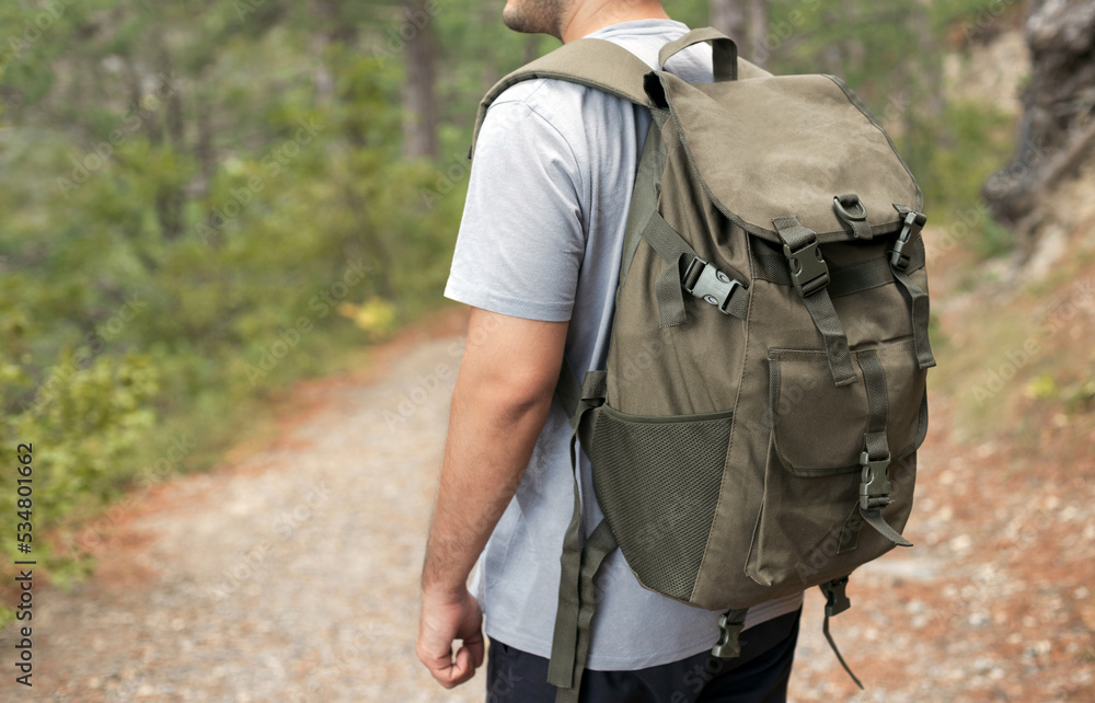 Close up side view of the man with large and comfortable tourist backpack with pockets. Active lifestyle concept. Close up side view of the man with large and comfortable tourist backpack with pockets. Active lifestyle concept.