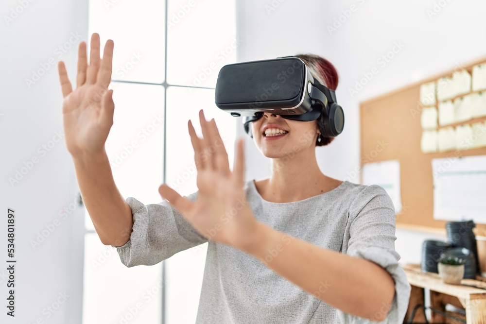Young caucasian businesswoman smiling happy using virtual reality glasses at the office. Young caucasian businesswoman smiling happy using virtual reality glasses at the office.