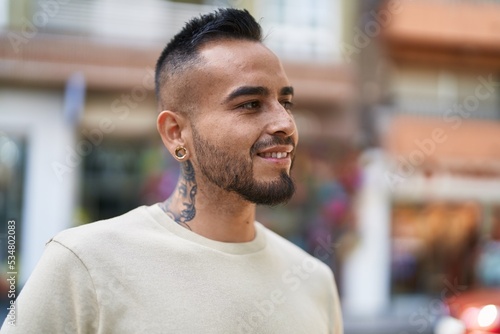 Young hispanic man smiling confident pointing with fingers at street