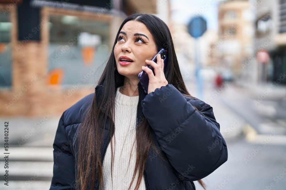 Young beautiful hispanic woman talking on smartphone with relaxed expression at street Young beautiful hispanic woman talking on smartphone with relaxed expression at street