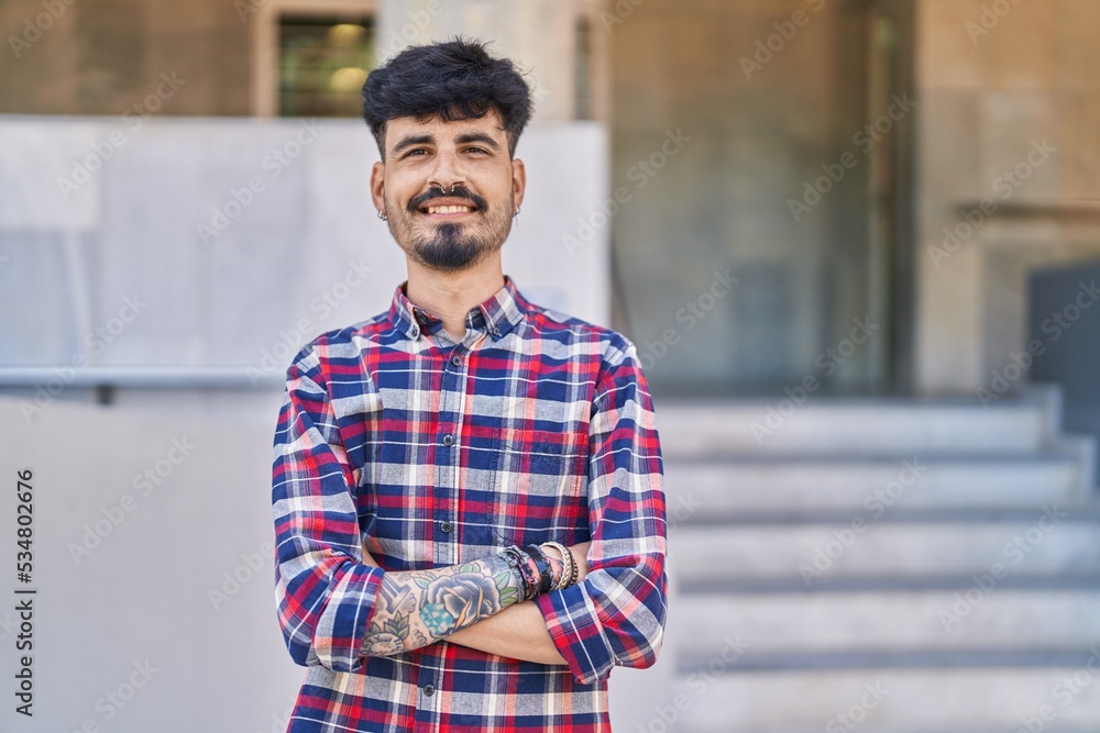 Young hispanic man smiling confident standing with arms crossed gesture at street Young hispanic man smiling confident standing with arms crossed gesture at street