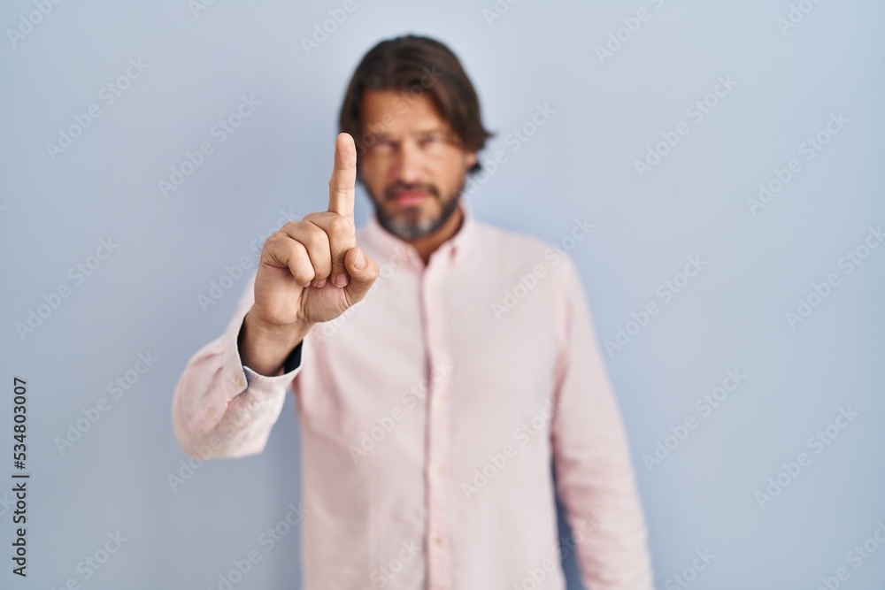 Handsome middle age man wearing elegant shirt background pointing with finger up and angry expression, showing no gesture Handsome middle age man wearing elegant shirt background pointing with finger up and angry expression, showing no gesture