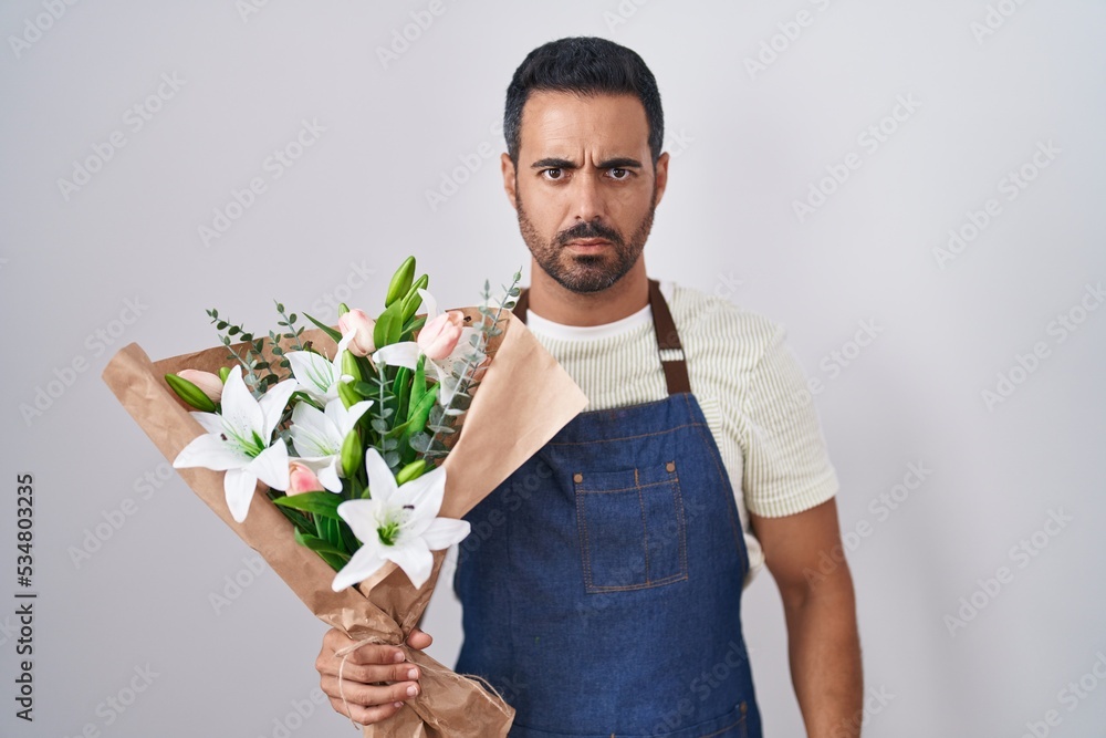 Hispanic man with beard working as florist skeptic and nervous, frowning upset because of problem. negative person. Hispanic man with beard working as florist skeptic and nervous, frowning upset because of problem. negative person.