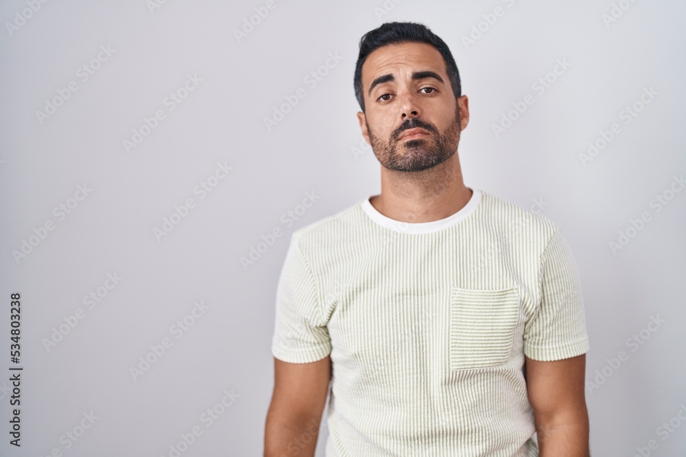 Hispanic man with beard standing over isolated background looking sleepy and tired, exhausted for fatigue and hangover, lazy eyes in the morning. Hispanic man with beard standing over isolated background looking sleepy and tired, exhausted for fatigue and hangover, lazy eyes in the morning.