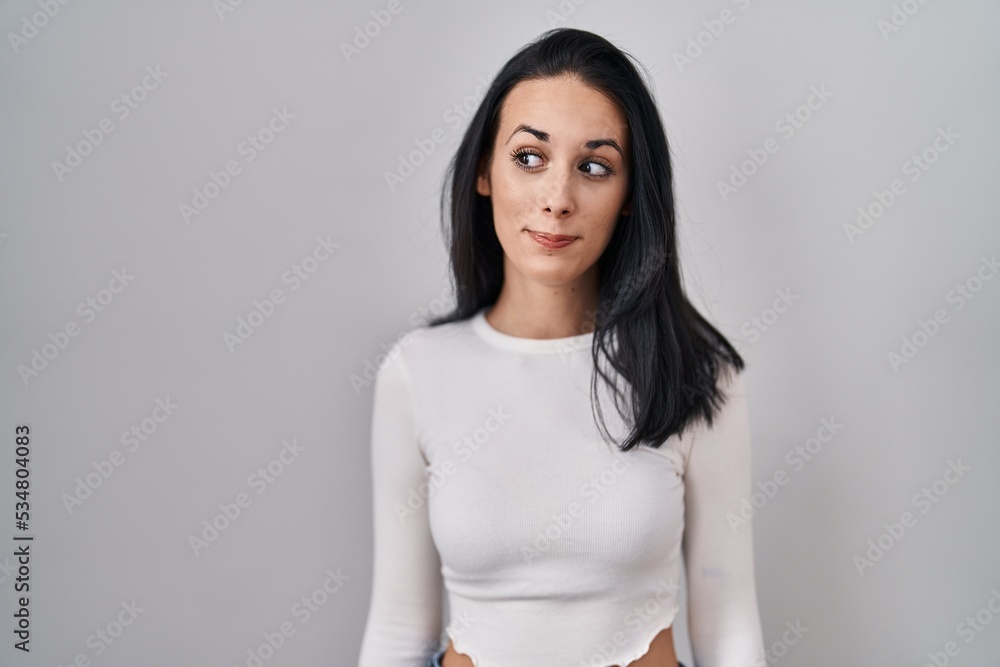 Hispanic woman standing over isolated background smiling looking to the side and staring away thinking. Hispanic woman standing over isolated background smiling looking to the side and staring away thinking.