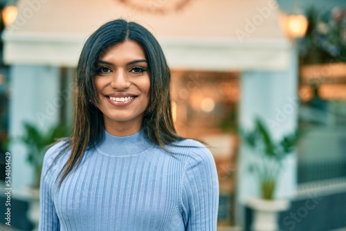 Beautiful hispanic woman smiling confient at the city