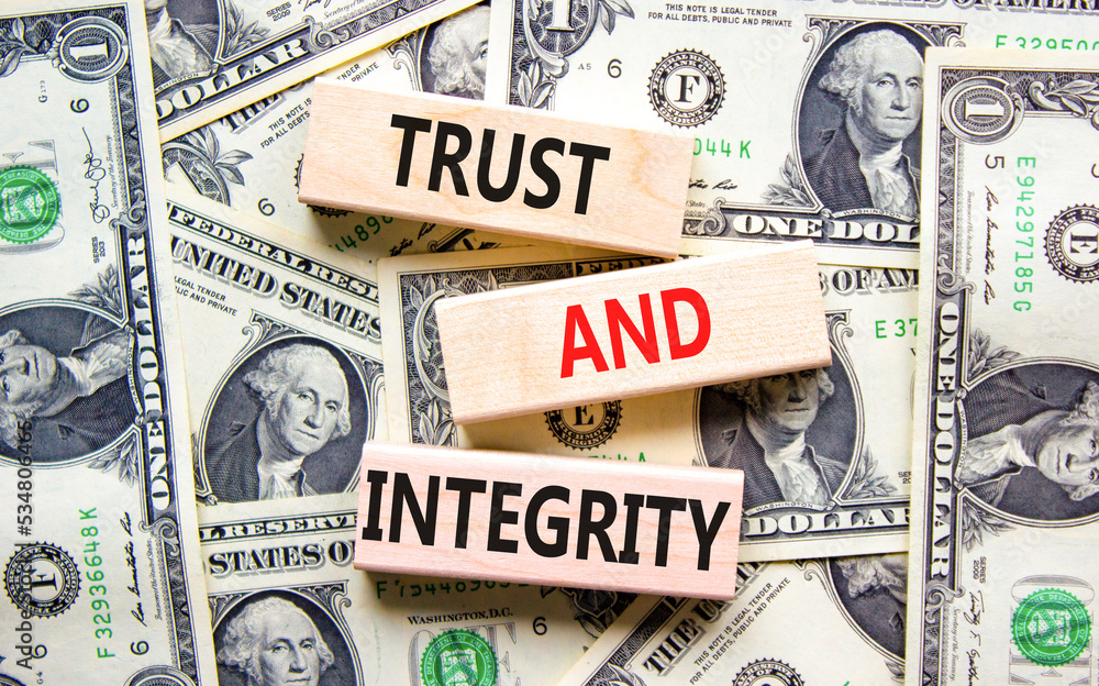 Trust and integrity symbol. Concept words Trust and integrity on wooden blocks. Dollar bills. Beautiful background from dollar bills. Business, psychological trust and integrity concept. Copy space.