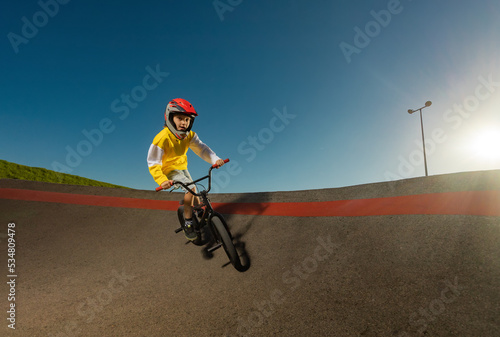 A Teenager BMX Racing Rider Performs Tricks on a Pump Track.