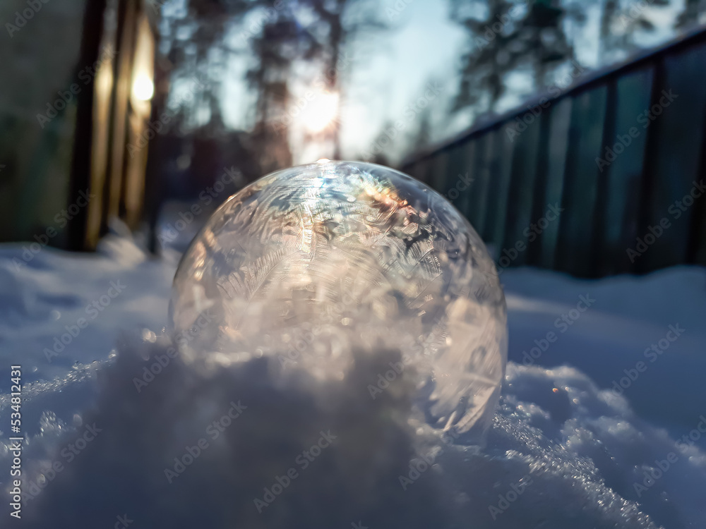 Macro of round, frozen soap bubble forming beautiful leaf and tree like pattern while freezing in very cold temperatures in winter Macro of round, frozen soap bubble forming beautiful leaf and tree like pattern while freezing in very cold temperatures in winter