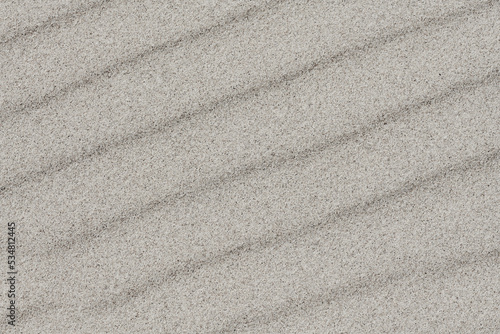 Różne formy piasku na morskiej plaży ukształtowane przez fale i wiatr.