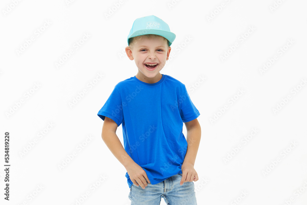 Stylish child boy laughing merrily with wide open mouth in a blue casual t-shirt and cap on a white isolated background Stylish child boy laughing merrily with wide open mouth in a blue casual t-shirt and cap on a white isolated background