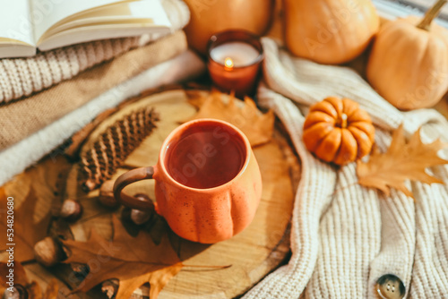 Autumn cozy decor, cup of tea, candles, pumpkins