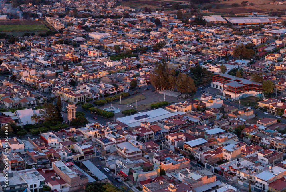Aerial: panorama view of city and streets during sunset in Mexico. Drone view