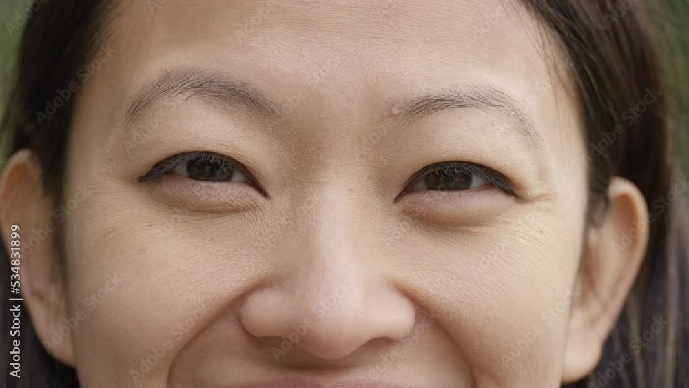 Young Asian female opens her eyes and smiles to camera Young Asian female opens her eyes and smiles to camera