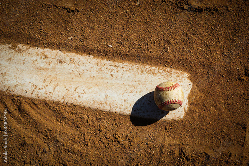 Baseball on pitcher's mound rubber on dirt field photo