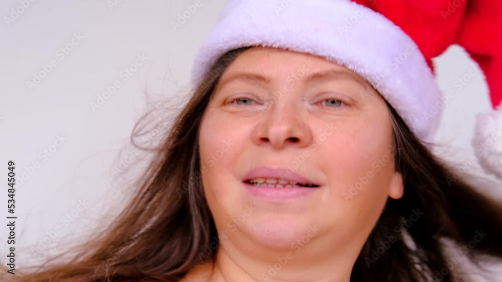 close-up of cheerful adult woman in santa claus red hat with long hair, having fun, festive mood, congratulations, good wishes, christmas concept, waiting for gifts, new year celebration close-up of cheerful adult woman in santa claus red hat with long hair, having fun, festive mood, congratulations, good wishes, christmas concept, waiting for gifts, new year celebration