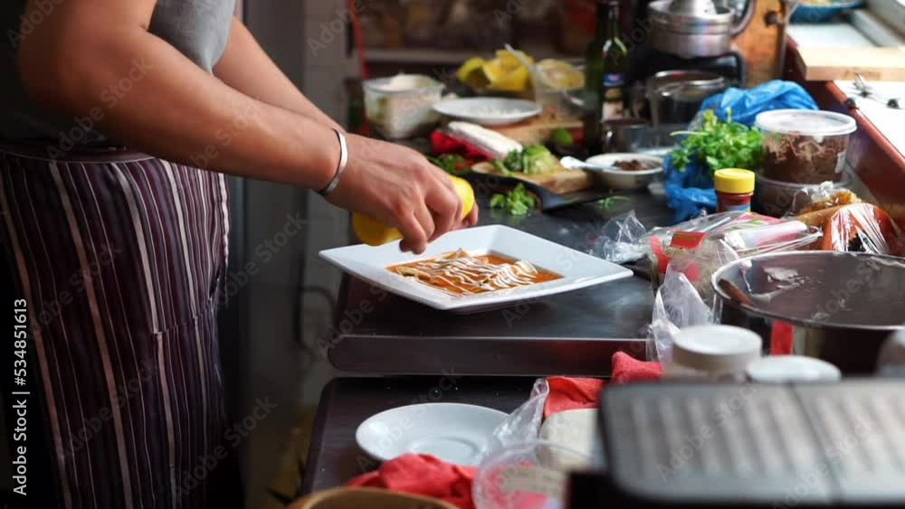 Close up of a chef putting cream and lettuce on enchiladas in a Mexican restaurant. Close up of a chef putting cream and lettuce on enchiladas in a Mexican restaurant.