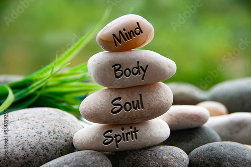 Photography Mind, Body, Soul and Spirit words engraved on zen stones with blurred nature background