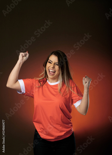 woman soccer fan cheering for her favorite club and team. world cup orange background