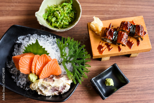 Top view of salmon sashimi and eel sushi on wooden table