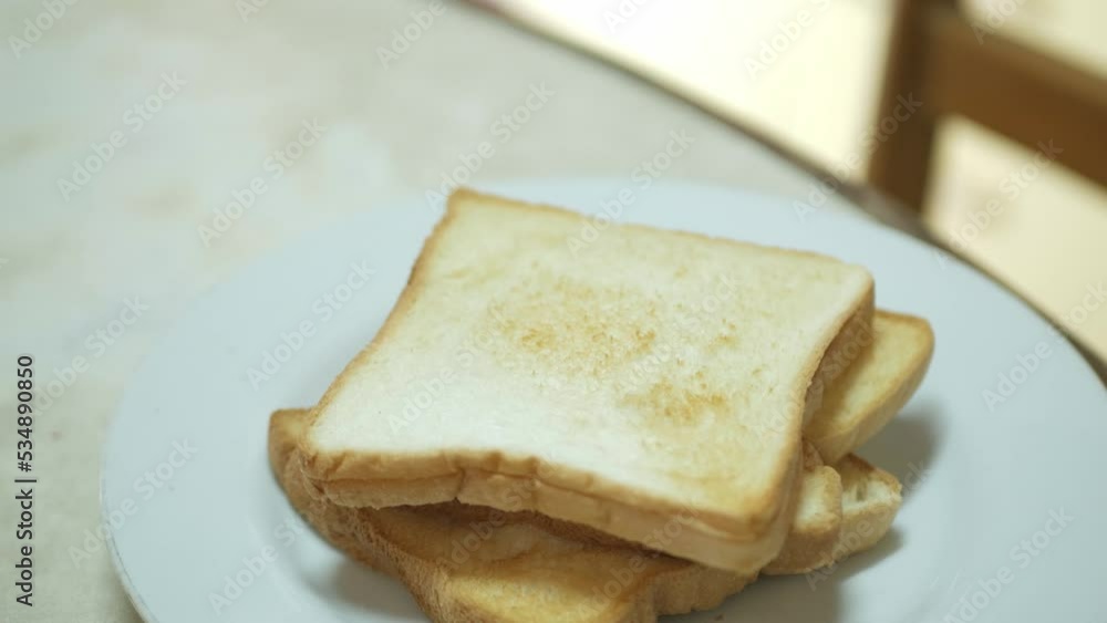 putting fresh toasted bread into white plate ready for healthy meal putting fresh toasted bread into white plate ready for healthy meal