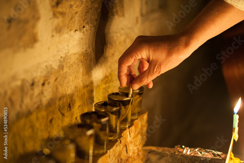 Closeup of a man's hand holding a wick and setting it in a vial of oil prior to lighting the Hanukkah menorah during the eight-day Festival of Lights in Israel.