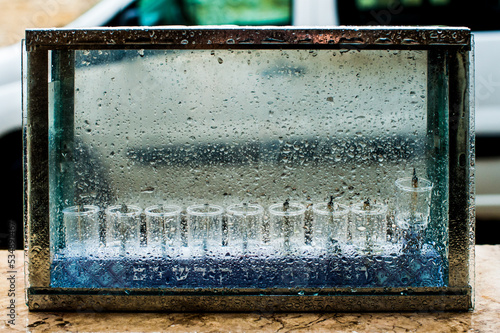 A glass housing protects unlit glass vials and wicks used to celebrate the Jewish holiday of Hanukkah during a daytime rainstorm in Israel. photo