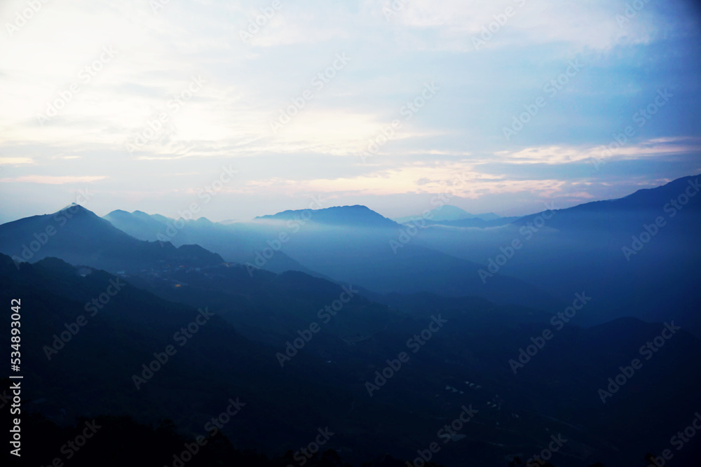 Clouds floating above mountain range in Ta Xua, Vietnam during early morning hours