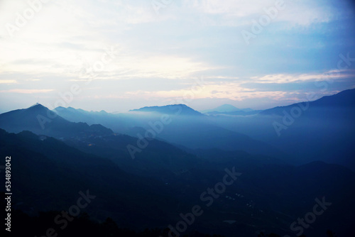 Clouds floating above mountain range in Ta Xua, Vietnam during early morning hours © hippomyta