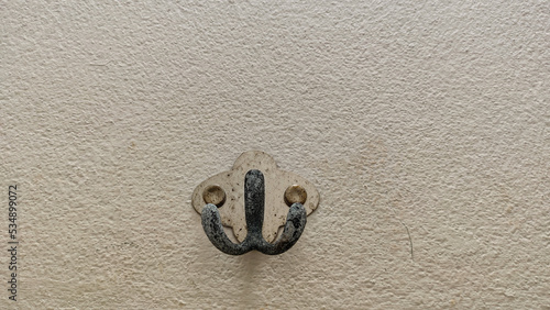 Old wall hanging hooks on the white wall.