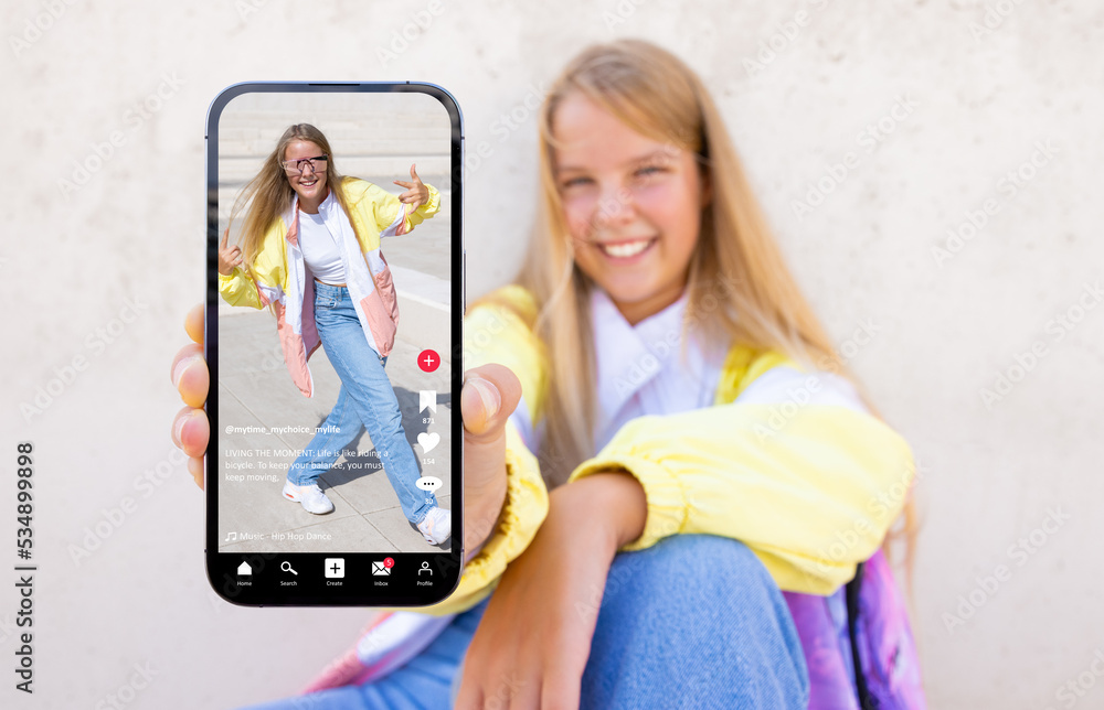 Teenage girl showing mobile phone with sample video content shared on social media - obrazy, fototapety, plakaty 