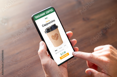 Person ordering coffee online for takeaway on mobile phone photo
