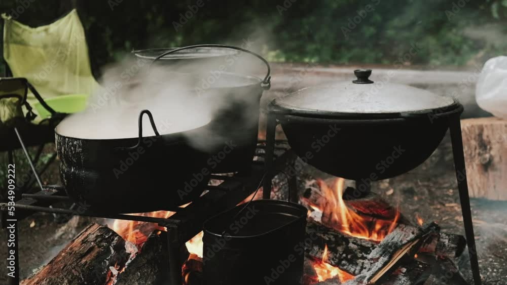 Camping food is cooked over a campfire.Active lifestyle, hiking concept.Slow motion. Camping food is cooked over a campfire.Active lifestyle, hiking concept.Slow motion.