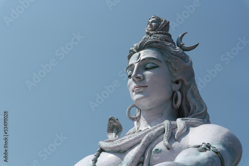 Beautiful big statue of meditating Shiva. Lord Shiva sits near the Ganges River at the foot of the Himalayas in Rishikesh, India. Yoga and meditation concept. photo