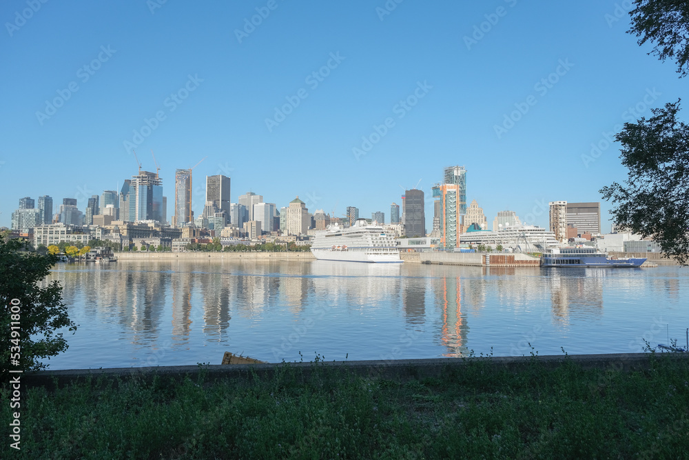 Fototapeta premium Viking cruiseship or cruise ship liner Star in port of Montreal, Canada on sunny day on St. Lawrence River for Indian summer East Coast cruising with downtown skyline and terminal