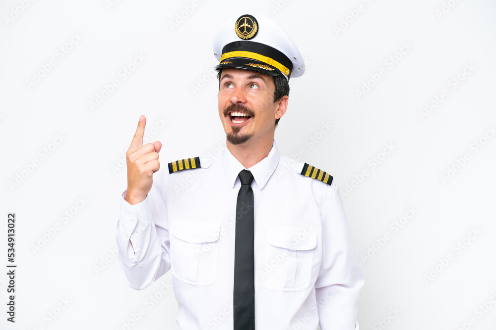 Airplane caucasian pilot isolated on white background pointing up and surprised Airplane caucasian pilot isolated on white background pointing up and surprised