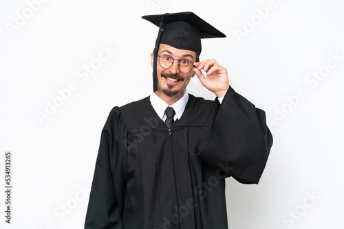Young university graduate man isolated on white background with glasses and happy