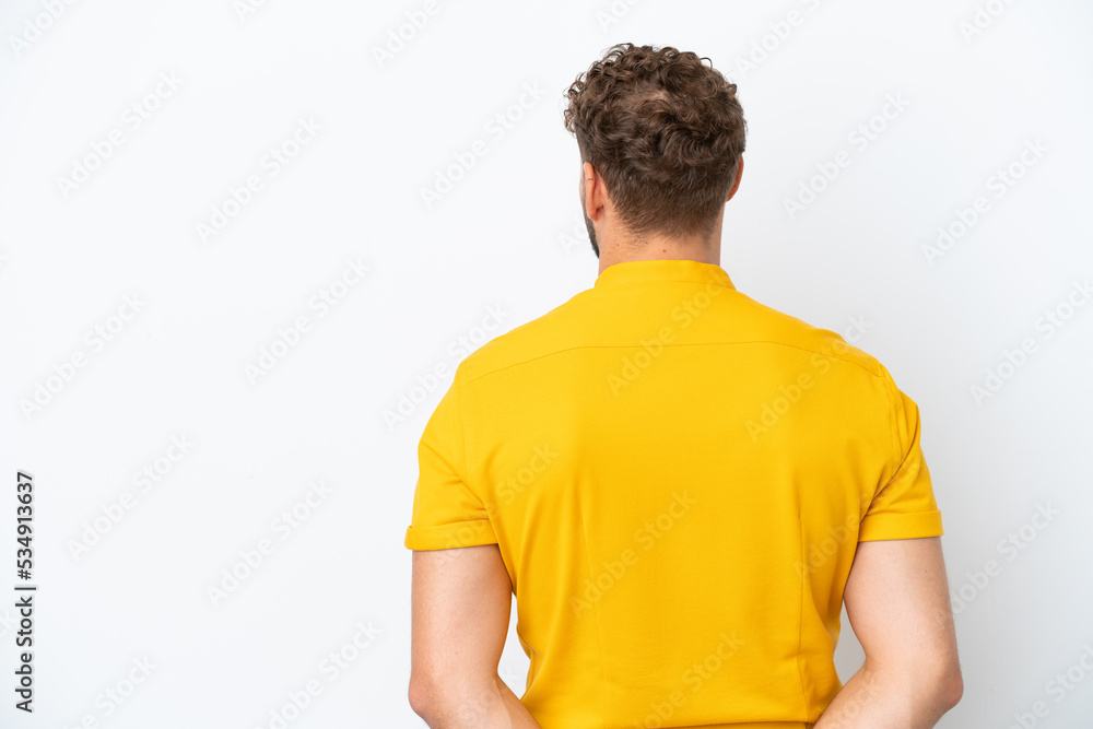 Young handsome caucasian man isolated on white background in back position and looking back Young handsome caucasian man isolated on white background in back position and looking back