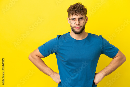 Young handsome caucasian man isolated on yellow background angry