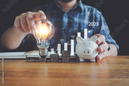 saving energy and money concept. idea for save or investment.businessman holding lightbulb for saving money wealth saving money coins on table concept financial.