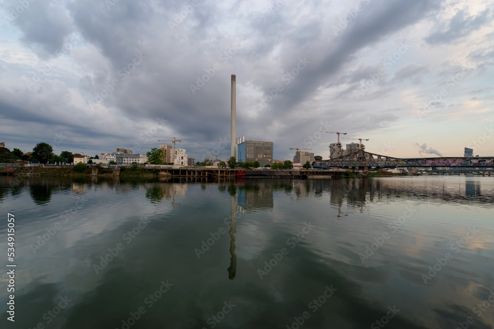 Seine river quay, power plant chimney and construction site in Grand paris area. Ivry-sur-Seine city