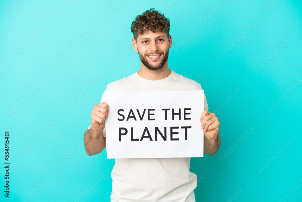 Young handsome caucasian man isolated on blue background holding a placard with text Save the Planet with happy expression Young handsome caucasian man isolated on blue background holding a placard with text Save the Planet with happy expression