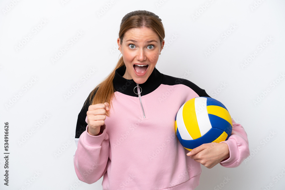 Young caucasian woman playing volleyball isolated on white background celebrating a victory in winner position Young caucasian woman playing volleyball isolated on white background celebrating a victory in winner position