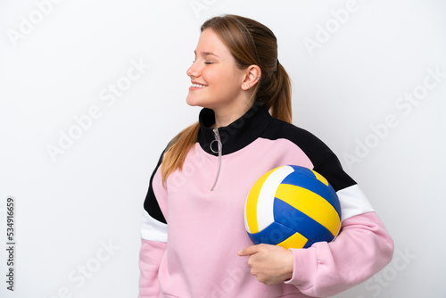 Young caucasian woman playing volleyball isolated on white background laughing in lateral position