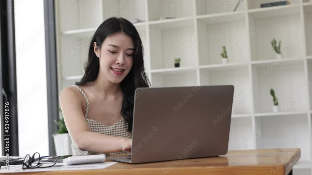 Asian woman smiling and talking for the camera at home office. video conferencing. Asian woman smiling and talking for the camera at home office. video conferencing.