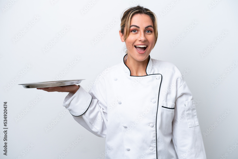 Young chef woman with tray isolated on white background with surprise facial expression Young chef woman with tray isolated on white background with surprise facial expression