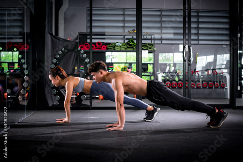Portrait young fitness woman under push up exercise at gym. she exercise for strong ,make muscle body building and good healthy concept