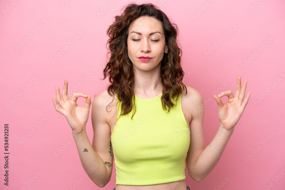 Young caucasian woman isolated on pink background in zen pose