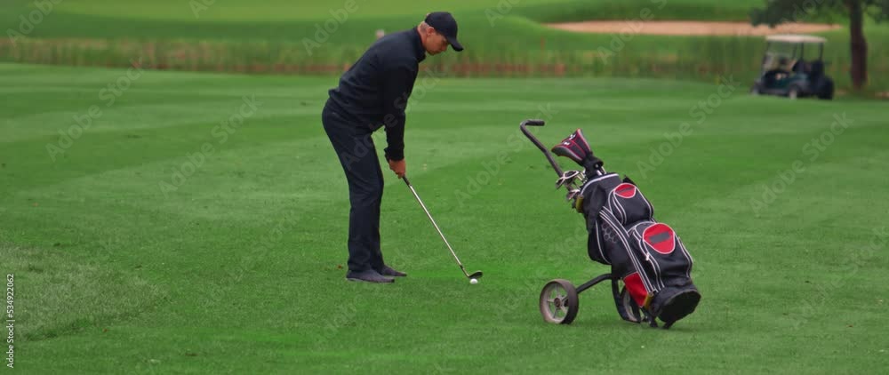 MED Caucasian man playing golf, striking a ball during the course. Super slow motion shot MED Caucasian man playing golf, striking a ball during the course. Super slow motion shot