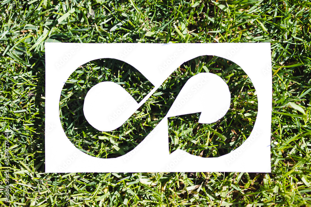 ecology and sustainability, circular economy symbol on paper cutout with perfect green grass filling it ecology and sustainability, circular economy symbol on paper cutout with perfect green grass filling it